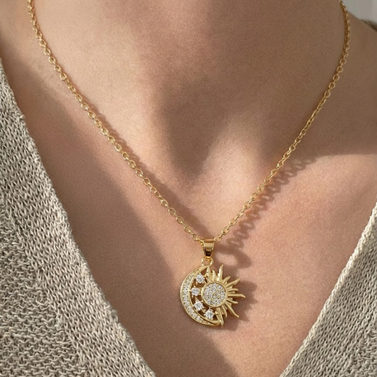 Gold necklace with a sun and moon pendant worn by a person