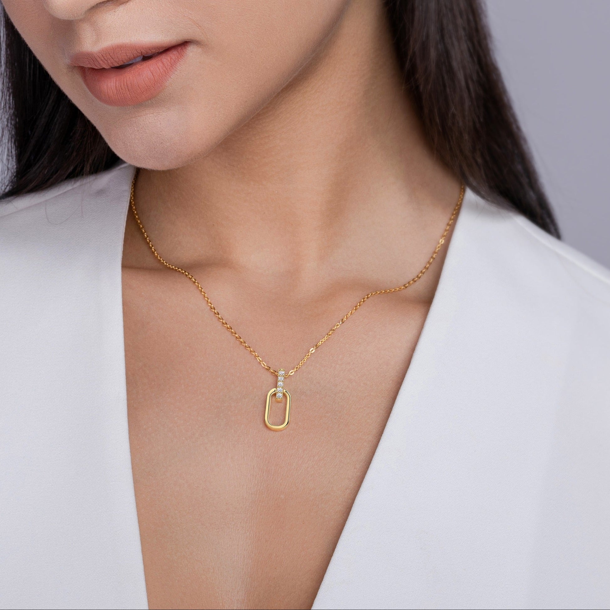 Woman wearing gold jewelry against a gray background