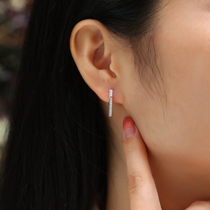 Close-up of an ear wearing a small hoop earring with a blurred background