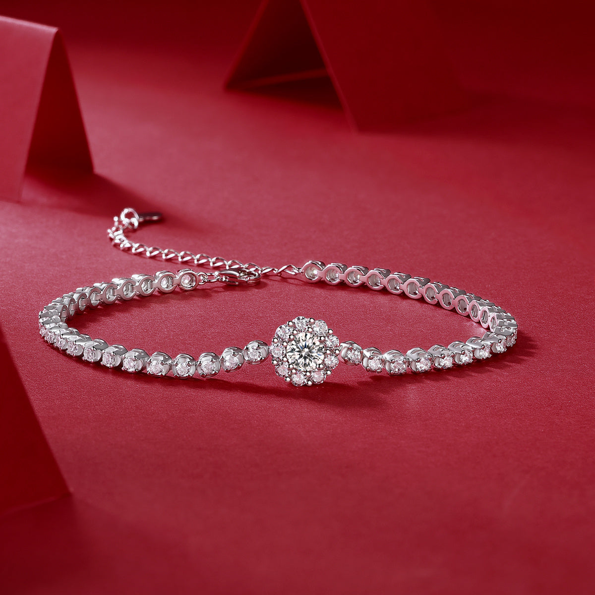 Silver bracelet with a decorative clasp on a red background